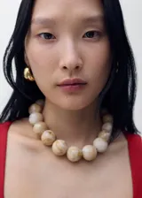 Chaleco de corte sastre con cuello escotado y tirantes anchos. Presenta cierre frontal con botones ocultos bajo tapeta y dos bolsillos de ribete delanteros. Confeccionado en una mezcla de viscosa, lino y algodón con forro interior de algodón.