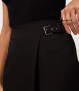 Short pollera de sastrería color marrón, confeccionado en mezcla de poliéster y viscosa, con diseño cruzado tipo envolvente.