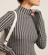 Suéter de cuello alto con estampado de pata de gallo en blanco y negro.