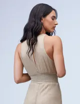 Enterito largo de gasa lurex plisada color dorado, con escote halter, cintura elastizada con punto smock, abertura en la espalda con cierre invisible y forro interno a tono.