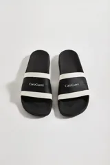 Sandalias tipo ojotas de goma color verde con franjas blancas horizontales y logo de la marca en relieve.
