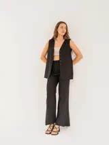 Chaleco color crema de lino con corte sastrero, largo a la cadera, forro interno, botones delanteros, silueta levemente entallada y tajo cruzado en la espalda.