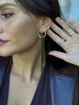 Aro colgante con base dorada y múltiples tiras de strass verde esmeralda.