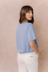 Remera negra de corte oversize con cuello redondo, mangas cortas amplias, hombros caídos y recortes delanteros.