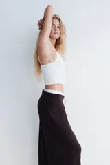 Pantalón de corte amplio confeccionado en tejido con textura tipo waffle, con cintura elástica y cordón ajustable.