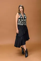 Falda negra de corte asimétrico con diseño irregular y volados que aportan movimiento. Presenta cintura elástica y una caída fluida.