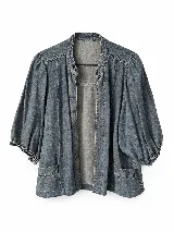 Chaqueta de denim azul con diseño abierto, mangas abullonadas tres cuartos con puños fruncidos y bolsillos frontales aplicados.