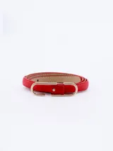 Cinto fino de cuero rojo con hebilla dorada en forma de U.