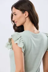 Remera de algodón color beige, de manga corta con volados de broderie, escote redondo y cuerpo liso.