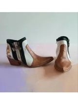 Bota corta de cuero tricolor en tonos marrón terracota, blanco, negro y detalles dorados, con diseño pintado a mano, punta fina y taco geométrico.