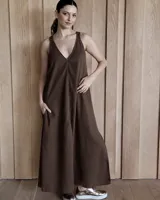 Vestido largo tipo solera de corte holgado, con escote en V, breteles anchos y bolsillos laterales. Presenta costuras a la vista y tajos laterales en el ruedo.