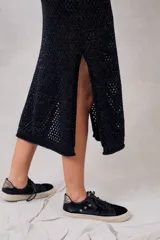 Vestido midi negro tejido a crochet con lurex, cuello redondo y sin mangas.