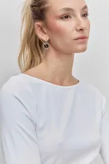 Remera de manga tres cuartos, color blanco, con cuello redondo y ajuste al cuerpo.