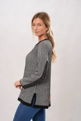 Sweater de punto con cuello redondo y mangas largas. Diseño a rayas verticales en tonos gris y negro.