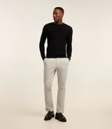 Pantalón de vestir para hombre, color beige claro, de corte slim y sastrería. Presenta cierre frontal con botón y cremallera, y bolsillos laterales y traseros.