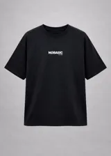 Remera boxy negra de manga corta, con cuello redondo y diseño amplio en hombros y cuerpo. Cuenta con un pequeño estampado frontal en blanco en el pecho con la inscripción "NØBASIC CLUB".