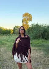 Ruana tejida en crochet color bordó, con diseño de calados horizontales y terminación con flecos largos en todo el borde inferior.