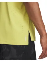 Musculosa deportiva Under Armour de running, color amarillo lima, con perforaciones láser laterales para ventilación y aberturas en el bajo. Presenta logo de la marca en el pecho y tecnología Iso-Chill para disipar el calor.