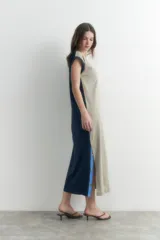 Vestido largo verde oliva con escote en V, sin mangas y detalle de botones a presión en los laterales.