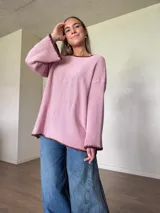 Sweater de punto jersey de algodón color rosado, con silueta oversize, cuello a la base y mangas acampanadas. Presenta terminaciones hechas a mano en crochet a contratono en tono marrón oscuro con detalles de lurex.