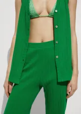 Pantalon de crochet color verde, de corte recto y largo, con cintura elástica y aberturas laterales en el bajo.