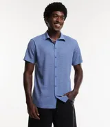 Camisa de punto abierto celeste con cuello inglés y mangas cortas, de corte relajado y cierre frontal con botones.