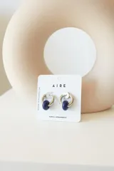 Aros de argolla en acero quirúrgico con dije de piedra natural en tono azul.