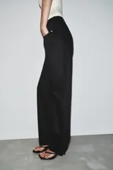 Jeans de tiro alto, pernera recta y larga, estilo clásico con cinco bolsillos, cierre frontal con cremallera y botón metálico.