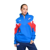 Buzo deportivo Umbro de mujer, color azul con detalles en blanco y rojo. Tiene cuello alto con cierre de media cremallera y logo de la marca bordado en el pecho.