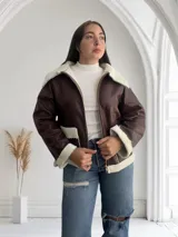 Campera marrón de ecocuero con interior de corderito blanco, cierre frontal con cremallera y bolsillos laterales.