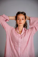 Camisa blanca de manga larga con detalle de bordados verticales en el frente y puños acampanados.