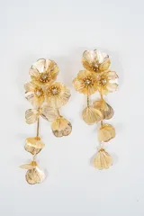 Aros colgantes largos de diseño floral, elaborados en metal dorado con acabado de filigrana y detalles de cristales incrustados en el centro de las flores.