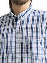 Camisa de hombre de manga corta con estampado a cuadros en tonos blanco, verde y marrón. Tiene cuello abotonado y bolsillo en el pecho.