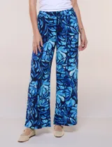 Pantalón de poliéster de corte ancho tipo palazzo y calce relajado, con estampado de hojas en tonos azules, cintura alta elastizada con cordón ajustable y bolsillos laterales.