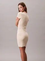 Vestido corto de manga corta confeccionado en tejido jersey de algodón con elastano. Presenta un corte slim ceñido al cuerpo, cuello redondo con detalle de canalé y el monograma de la marca bordado en el pecho.