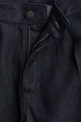 Jean de cinco bolsillos en denim de algodón color azul oscuro, de tiro medio y pierna recta muy ancha. Presenta pliegues cosidos marcados en el frente de cada pierna.