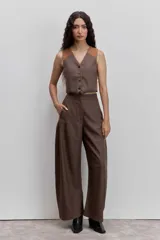 Pantalon de vestir de corte wide leg, color marrón con estampado de rayas diplomáticas finas. Presenta cintura alta, bolsillos laterales y cierre frontal.