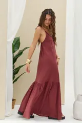 Vestido largo bordó de corte amplio, con tirantes finos ajustables y falda con volados en la parte inferior.