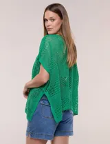 Poncho de tejido calado color beige, con mangas cortas, aberturas laterales y lazos ajustables en el cuello. Modelo Do Everything In Love.