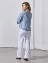 Blusa celeste de lyocell con cuello a la base y escote en V con lazo de ajuste. Manga larga amplia.