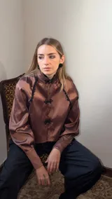 Tapado corto de tafeta marrón con cuello mao, mangas abullonadas, puños anchos y cierres de estilo oriental con detalles de encaje negro.