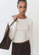 Jersey de punto fino con cuello redondo y manga larga, de diseño entallado al cuerpo.