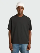 Remera de algodón color negro, de corte holgado y cuello redondo, con detalle de logo invertido en la espalda.