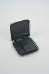 Billetera cuadrada de color verde menta con textura de efecto piel de reptil y cierre perimetral metálico.