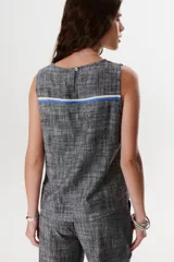 Top sin mangas de corte recto y holgado, confeccionado en tejido de lino con textura jaspeada en tono azul. Presenta cuello redondo y un diseño minimalista ideal para climas cálidos.