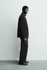 Blazer de corte regular confeccionado en piel con acabado de ante. Presenta cuello con solapas de muesca, cierre frontal de dos botones, bolsillos con solapa en la cadera y aberturas en la espalda.