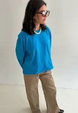 Remera oversize de manga larga y ancha, color celeste, confeccionada en algodón con cuello redondo.