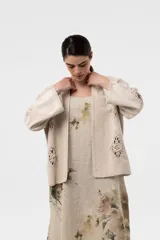 Chaqueta de gamuza color beige, con calce amplio y relajado, mangas anchas y detalles de inserciones de crochet con motivos florales.