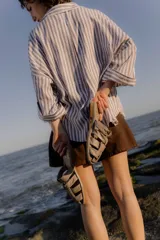 Sandalias bajas color beige con tiras de cuero entretejidas.