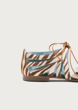 Ballerinas planas Defloresyfloreros modelo Gladiolo, confeccionadas con exterior de cuero con estampado animal print tipo cebra en tonos marrón y blanco, combinado con paneles de rejilla. Cuentan con cordones frontales finos con borlas decorativas verdes y suela de cuero con tacón de 1,5 cm.